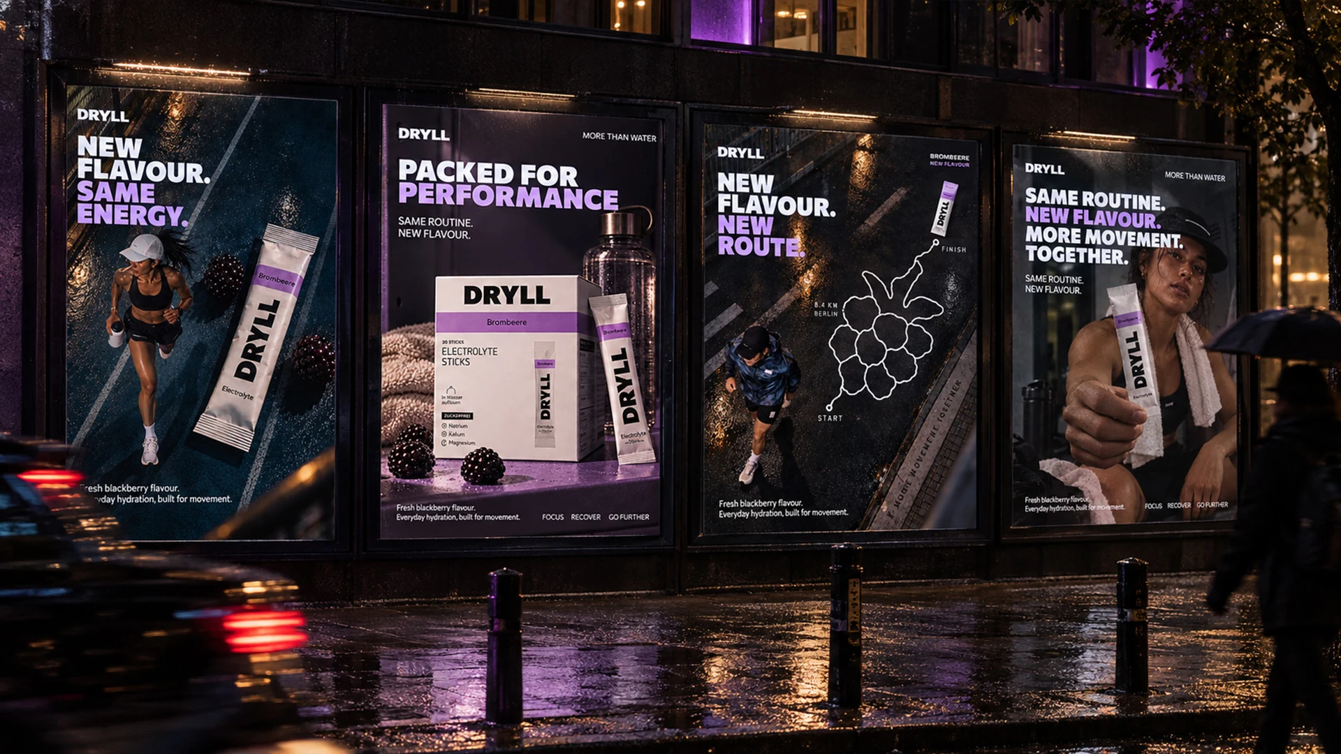 Four DRYLL launch posters displayed together on a wet city street at night