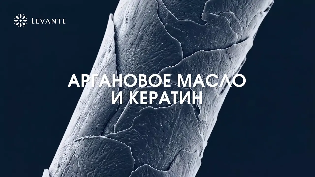 Macro frame of a hair strand on a dark blue field with a product line of text